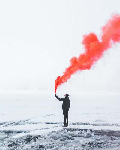 oeschinen lake person wearing black jacket and holding red colored smoke flare during daytime kandersteg
